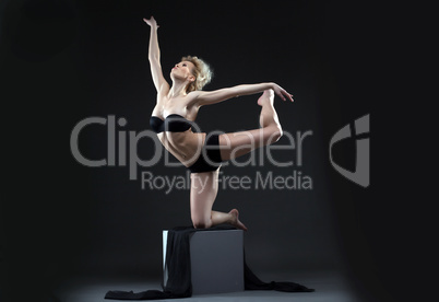 Image of seductive young dancer balancing on cube