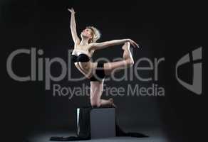 Image of seductive young dancer balancing on cube