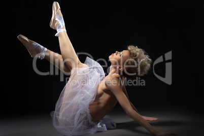 Elegant topless ballet dancer lying in studio