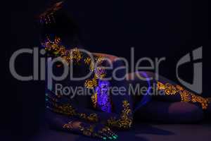 Sensual girl posing nude under ultraviolet light