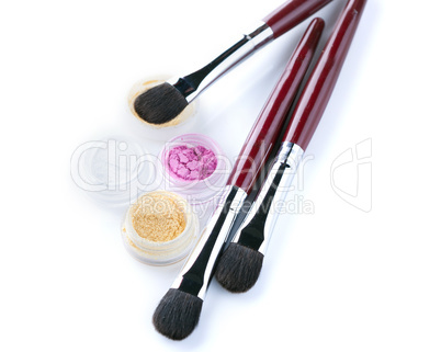 Cosmetic brushes and eyeshadows isolated on white