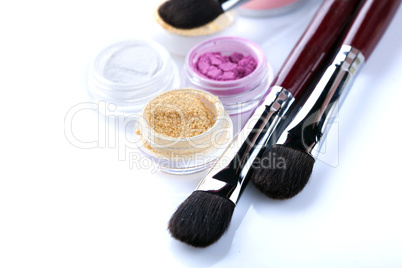 Cosmetic brushes and crumbly eyeshadows, close-up