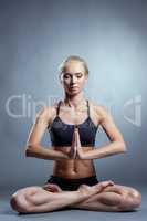 Pretty young blonde meditating in lotus position