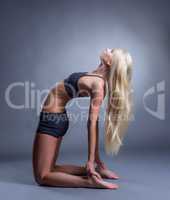 Attractive slim yoga trainer posing in studio