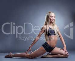Cute long-haired blonde doing stretching exercises