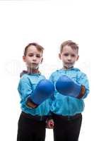 Two serious twins posing in boxing gloves