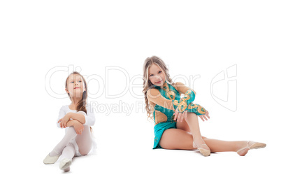 Two adorable young gymnasts posing in studio