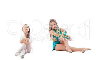 Two adorable young gymnasts posing in studio