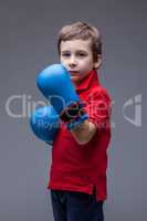 Serious handsome boy posing in boxing gloves
