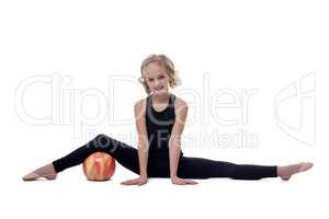Cheerful flexible young gymnast posing on split
