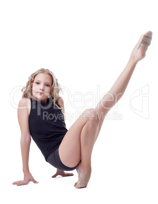 Cute young gymnast doing stretching exercises