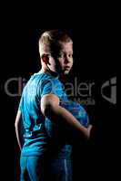 Portrait of sporty boy with ball isolated on black