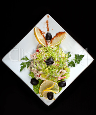 Tasty meat salad decorated with lemon and olives