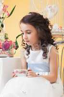 Lovely melancholy little girl drinking tea