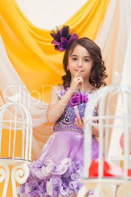 Smart little brunette posing in decorated studio