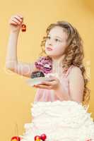Adorable little girl posing with cake in studio