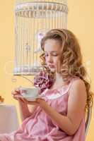 Portrait of pretty curly girl drinking tea