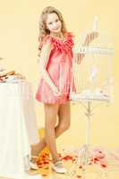 Pretty little girl posing in elegant pink dress