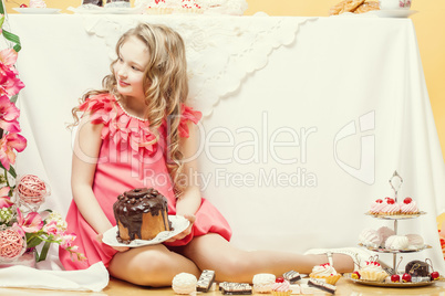 Smiling elegant girl posing with tasty cakes