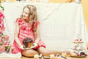 Smiling elegant girl posing with tasty cakes