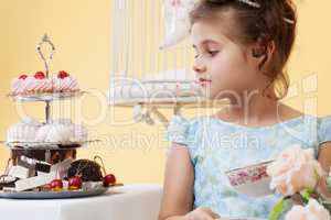 Portrait of pretty smart girl looking at sweets