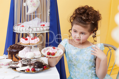 Elegant little girl posing with plate of sweets