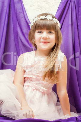 Portrait of funny little girl in pink smart dress