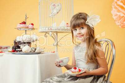 Cute elegant girl drinking tea with cakes