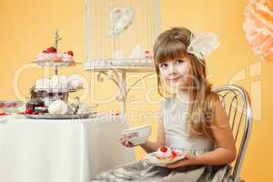 Cute elegant girl drinking tea with cakes