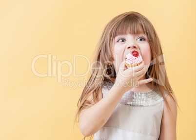 Little sweet tooth eats cake, on yellow background