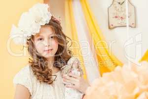 Attractive young girl posing with doll