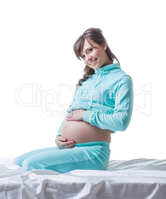Sensual smiling expectant mother posing in studio