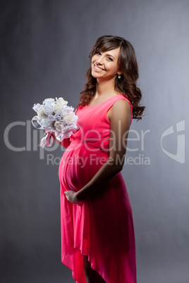 Elegantly dressed pregnant woman smiling at camera