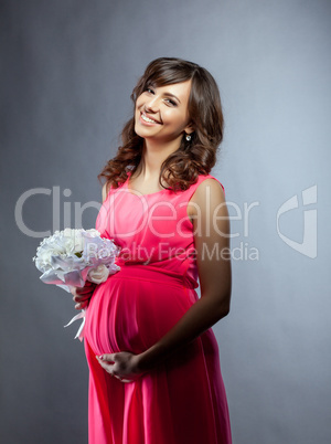 Happy elegant pregnant woman smiling at camera