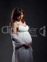Relaxed pregnant woman embracing her belly