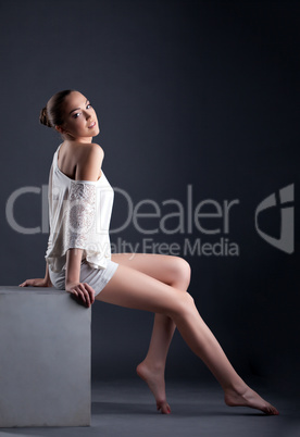Attractive young model posing sitting on cube