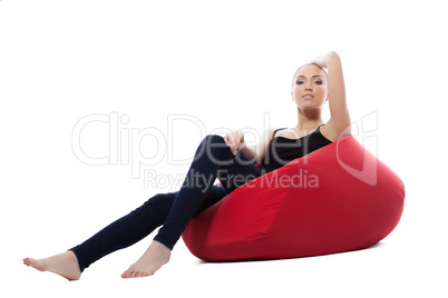 Slim woman in casual clothes posing on red couch