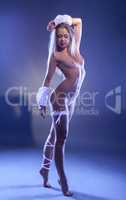 Smiling nude woman dancing in fluorescent light