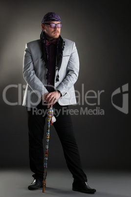 Image of racy man posing with cane in studio