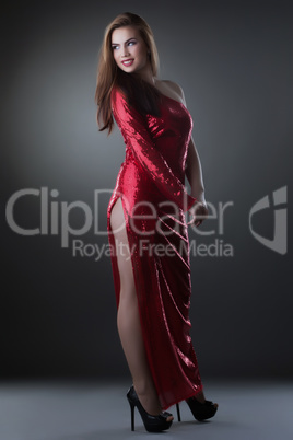 Curvy smiling woman posing in red long dress