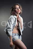 Charming model posing topless in jeans suit