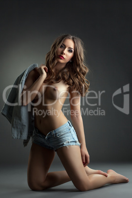 Hot young model posing topless in denim shorts