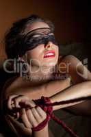Beautiful girl blindfolded posing with hands bound