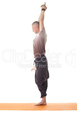 Side view of relaxed yoga man standing on one leg