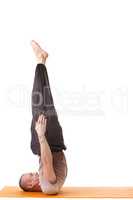 Athletic man doing yoga exercises in studio