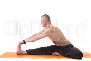 Athletic man with naked torso practicing yoga