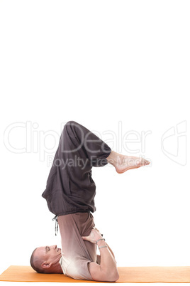 Side view of sporty man posing in difficult asana