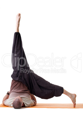Flexible man doing yoga in loose-fitting clothing