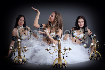 Charming belly dancers posing with chandeliers