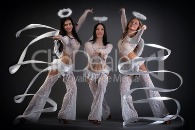 Lovely young women dancing with ribbons in studio